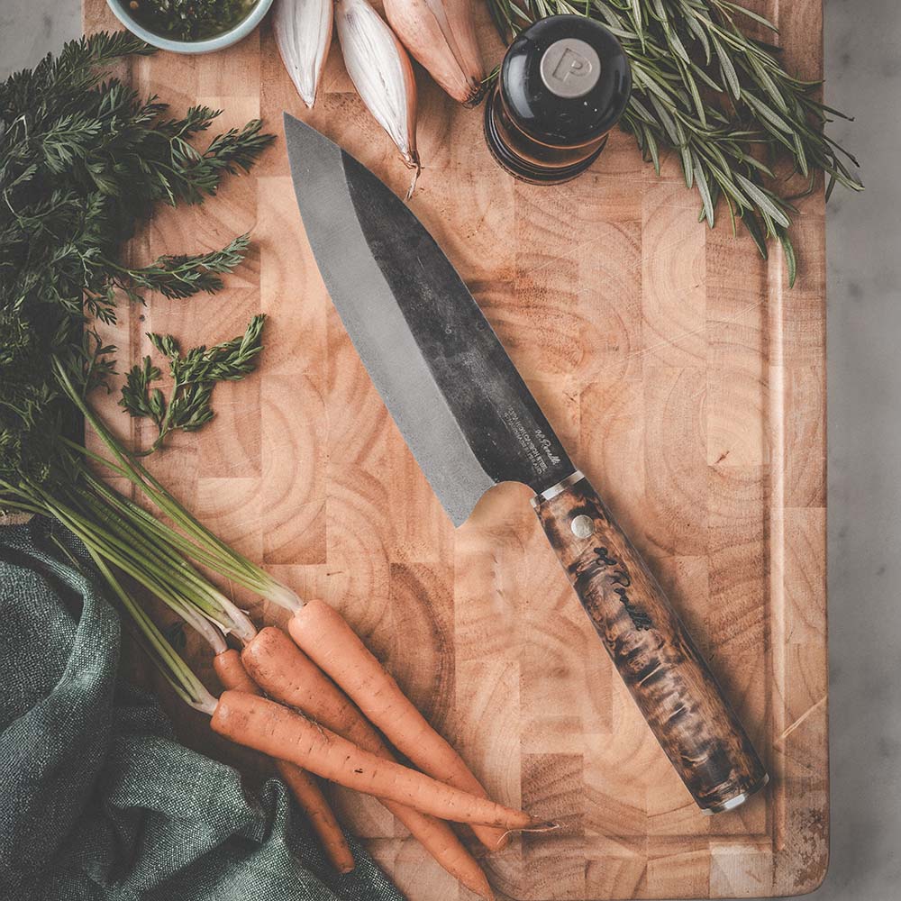 Roselli's handcrafted Santoku kitchen knife in high-carbon steel (UHC steel) with a stained curly birch handle. Delivered with a handmade leather sheath.